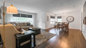 Un salon moderne comprenant un canapé, une table basse et un coin repas avec des chaises et une table.