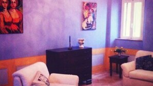 Un salon avec deux canapés, une petite table et des œuvres d’art accrochées aux murs.