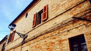 Un bâtiment historique caractérisé par sa maçonnerie apparente et ses volets en bois traditionnels.