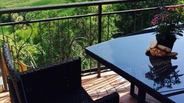 Un balcon avec une table et des chaises donnant sur un paysage magnifique.