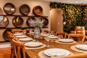 Un coin repas avec une table en bois dressée pour le repas, entourée de chaises en bois.