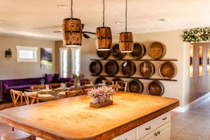 A kitchen with a large island, hanging wooden light fixtures, and a wall of decorative plates.