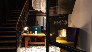 A modern interior with a staircase, a desk with a computer, and a sofa.