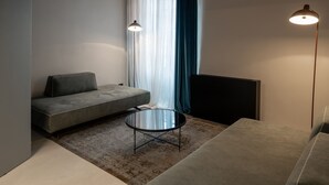 A modern living room with a grey sofa, a round coffee table, and a floor lamp.