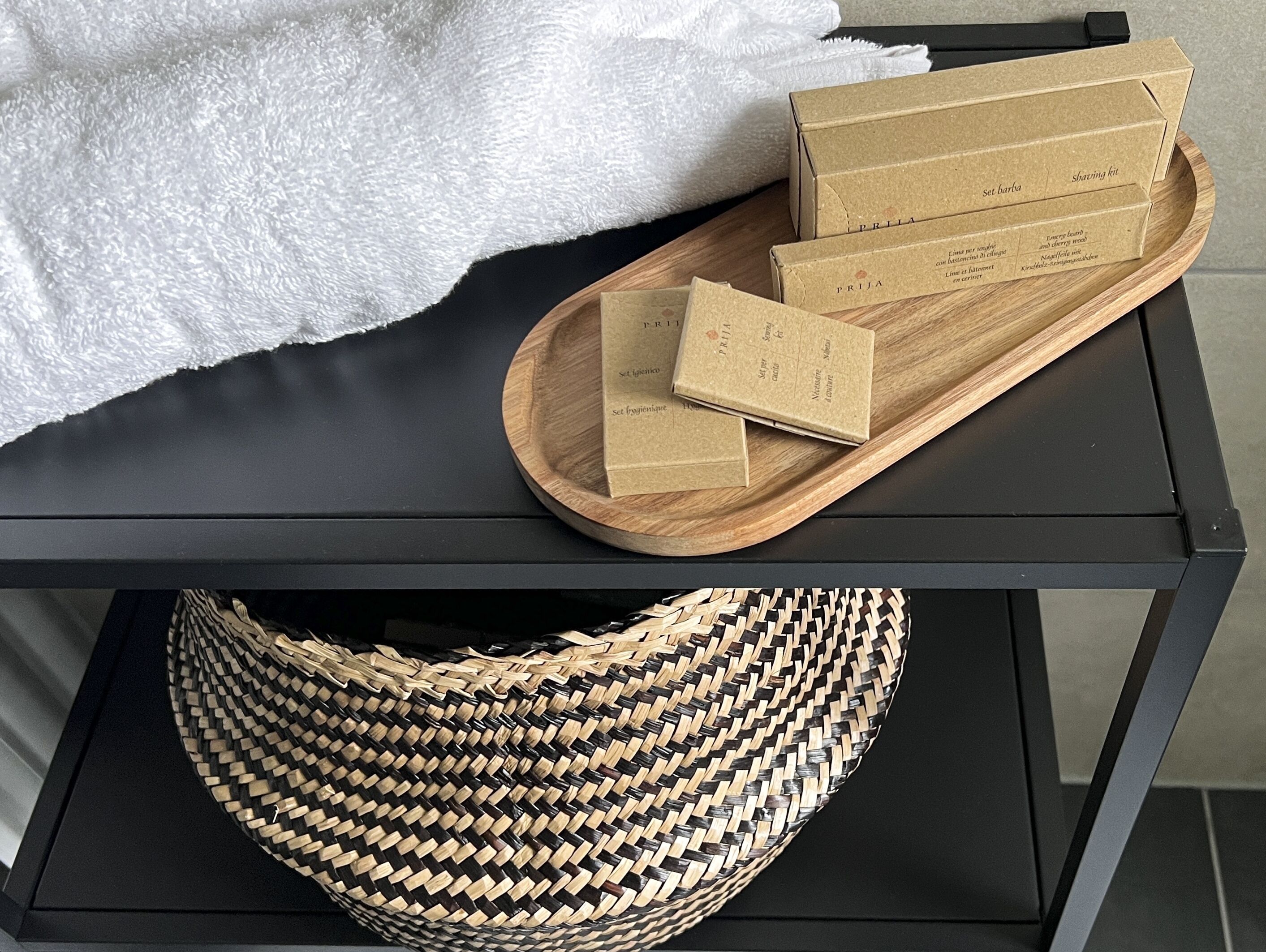A black metal table with a woven basket and three cardboard boxes on it.