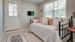 A bedroom with a bed, a TV, a compass wall decoration, and a window with blinds. - Canyon Lake Vacation Rental < 1/2 Mi to Water! (Canyon Lake)