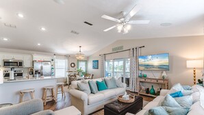 A spacious living area with a sofa set, a coffee table, and a dining table with chairs.