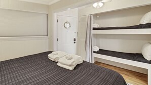 Une chambre à coucher avec un lit, une armoire et une porte dotée d’un miroir.