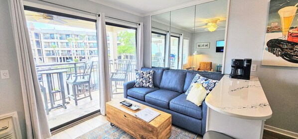 Relax in this stylish living room with a sofa, coffee table, and balcony access.