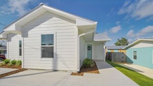 A single-story house with a front porch, a small front yard, and a neighboring house. - Stunning NEW / 2BR/Walk to Beach/Sleeps 5/Bunk (Panama City)