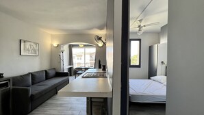 A modern, compact living space with a sofa, a dining table, and a bed. - Bright 26 m² with pool in Frejus (Fréjus)