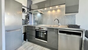 A modern kitchen with stainless steel appliances, a built-in oven, and a dishwasher. - Bright 26 m² with pool in Frejus (Fréjus)