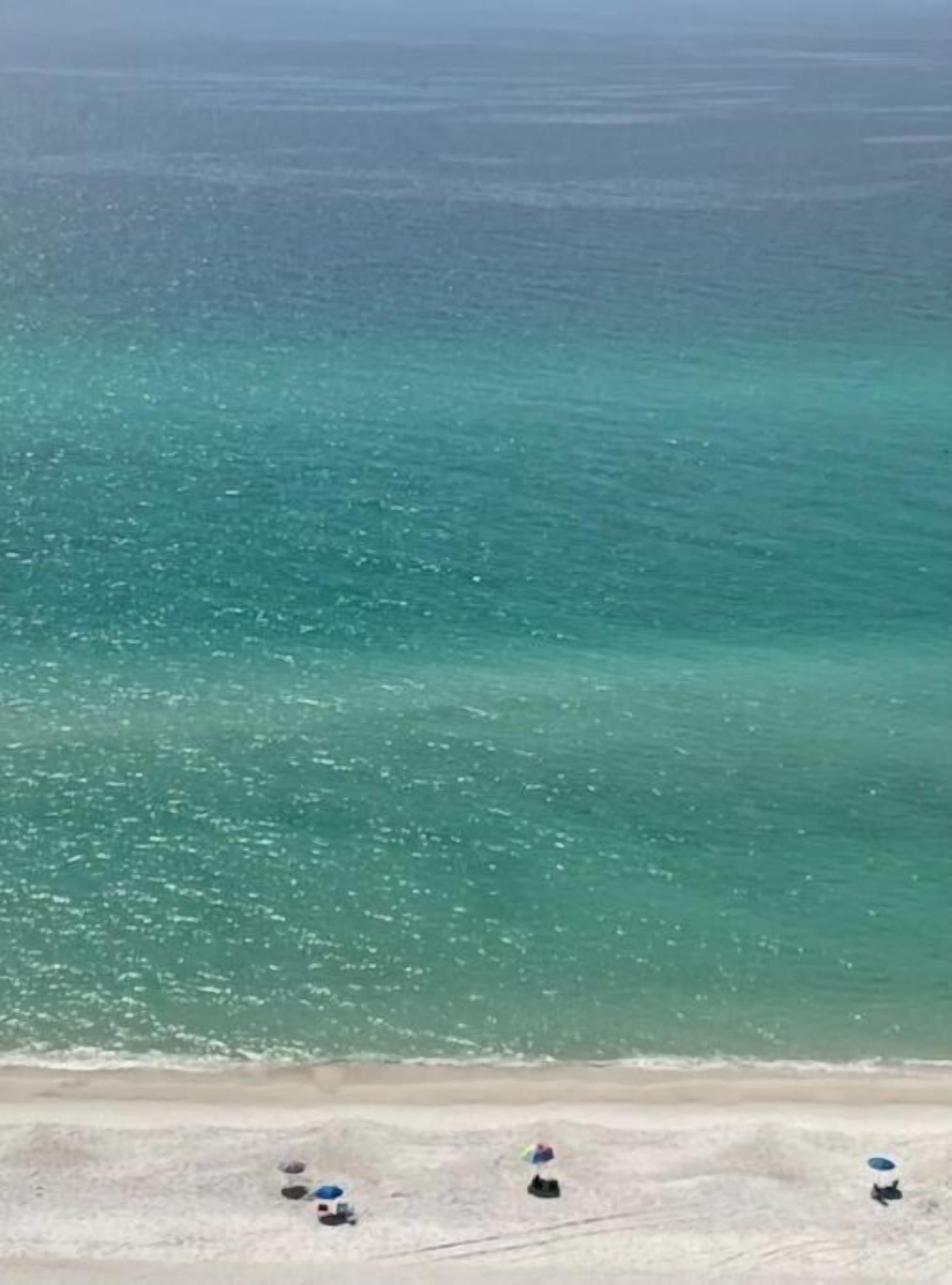 Ein Strand mit klarem türkisblauem Wasser und einem sandigen Ufer.