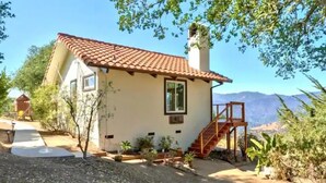 Une maison de plain-pied avec un toit en tuiles, une cheminée et un petit porche.