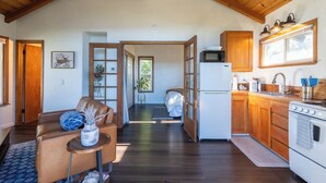 Une cuisine spacieuse avec des meubles en bois, un réfrigérateur et une cuisinière. On y trouve également un coin repas avec un canapé en cuir et une petite table.
