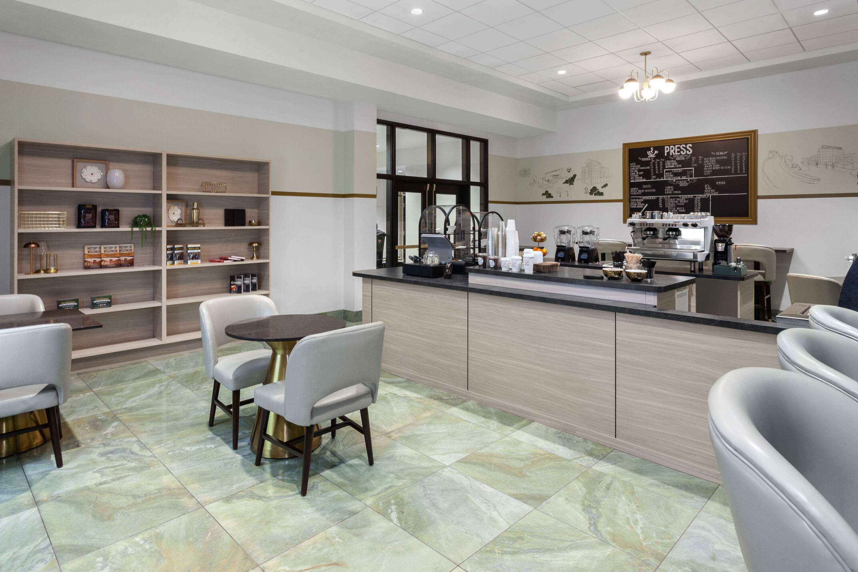 A modern cafe with a counter, seating area, and shelves with items.