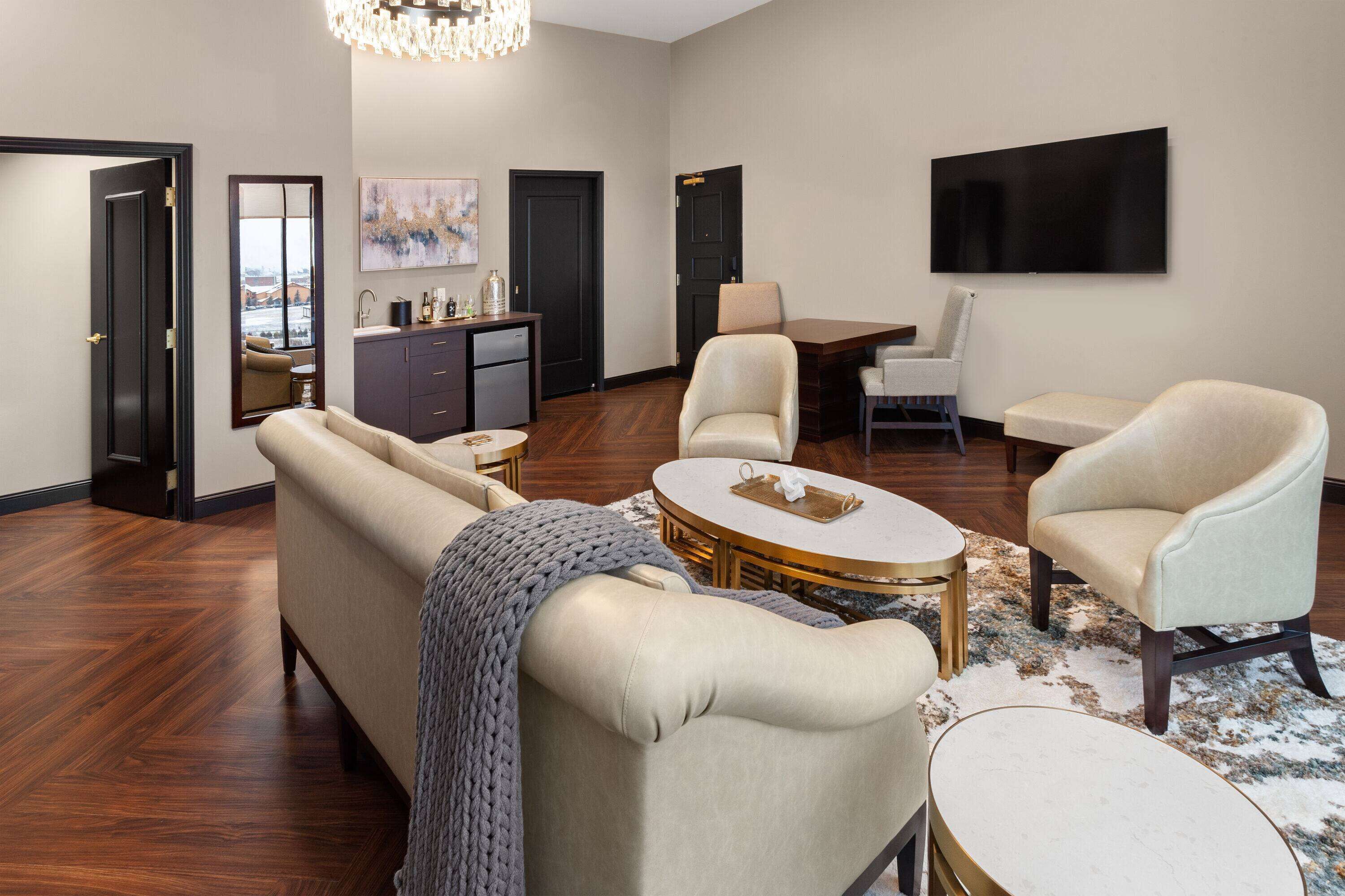 A spacious living room with a sofa, armchairs, a coffee table, and a dining area.
