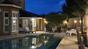 A pool area with lounge chairs, a small pool, and a building with stone walls and a balcony. - The Q Hotel (Shanklin)
