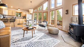 A spacious living area with a fireplace, large windows, and a cozy seating arrangement. - *NEW* Stunning Mountain Views/Hot Tub/3BR/Sleeps 6 (Fairplay)