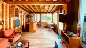 L’intérieur d’un chalet en bois comprend un coin repas, une cuisine et un espace salon.