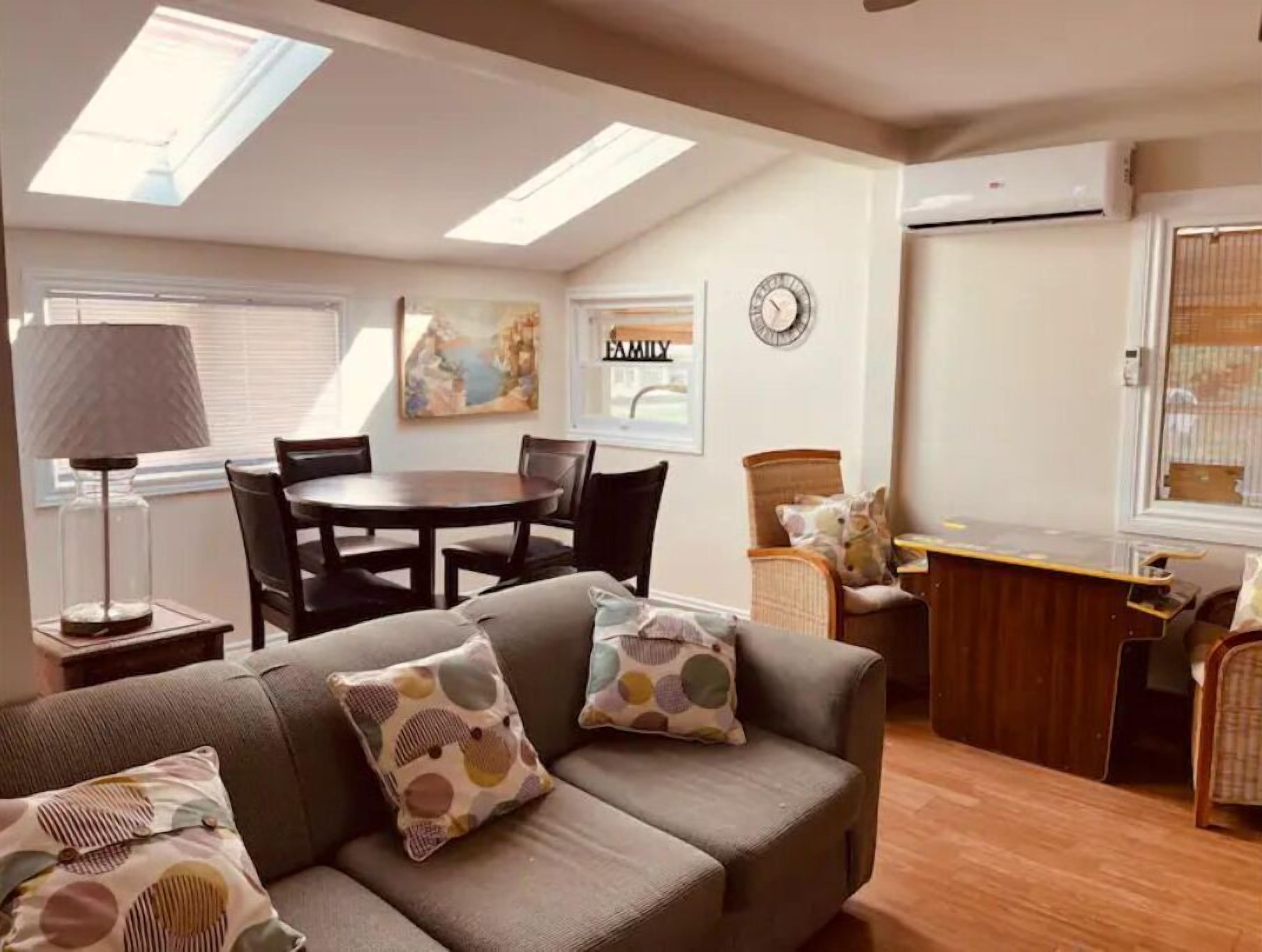 A cozy living room with a sofa, a dining table, and a kitchen area.