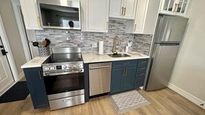 Una cucina moderna con piano cottura, lavastoviglie e frigorifero in acciaio inossidabile.