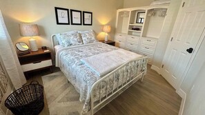 A bedroom with a bed, bedside tables, a wardrobe, and a mirror. - Turtle Nest 5 - Quick Walk to Beach (Fort Myers Beach)