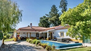 A two-story house with a tiled roof, a swimming pool, and a garden. - Farmhouse Sleeps 8 With Pool & Horses (Alcobaça)