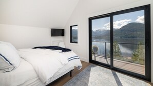 A bedroom with a large window offering a view of a lake and mountains. - Stunning Lake Views near RMNP with Hot Tub (Grand Lake)