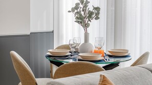 A dining table set with plates, glasses, and a vase with a plant. - Downtown Bliss w/ AC by LovelyStay (Porto)