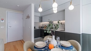 A modern kitchen with a dining area, equipped with a coffee maker, toaster, and a plant. - Downtown Bliss w/ AC by LovelyStay (Porto)