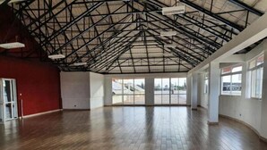 A spacious indoor area with a high ceiling and a metal truss structure. - Greenzone BnB (Kiambu County)