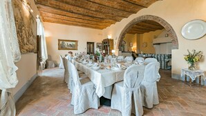 A dining area with a long table set for a meal, brick ceiling, and a rustic archway. - Villa Mimi - Nine Bedroom Villa, Sleeps 18 (Castroncello)