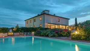 A large building with a swimming pool, surrounded by lush greenery and flowering plants. - Villa Mimi - Nine Bedroom Villa, Sleeps 18 (Castroncello)