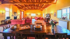A spacious living area with a wooden ceiling, a dining table with chess set, and a cozy seating arrangement. - Villa Faruffini - Four Bedroom Villa, Sleeps 8 (Magliano Sabina)