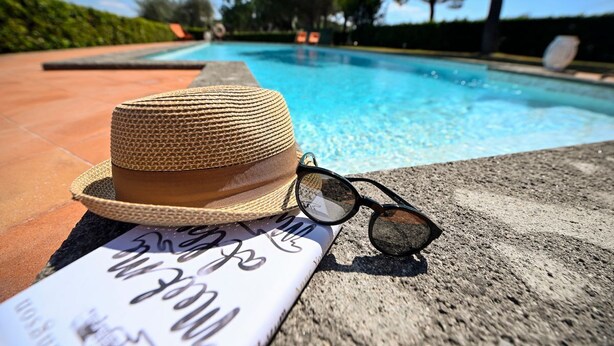 A hat and sunglasses on a towel by a pool with clear blue water and a tiled edge. - Villa Faruffini - Four Bedroom Villa, Sleeps 8 (Magliano Sabina)