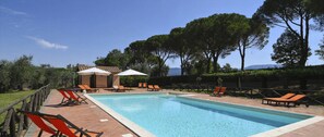 A rectangular swimming pool with a tiled edge, surrounded by orange lounge chairs and white umbrellas. - Villa Rovani - Eight Bedroom Villa, Sleeps 16 (Magliano Sabina)