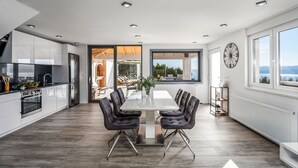 Una cocina moderna con comedor, ventanas amplias y vistas al exterior.