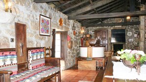 A rustic interior with stone walls, wooden furniture, and a stone fireplace. - Villa Estora - One Bedroom Villa, Sleeps 2 (Estorãos)