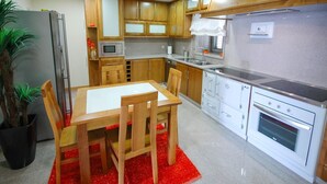 A modern kitchen with wooden cabinets, a stainless steel refrigerator, a microwave, a sink, and a stove. - Villa Anabela - Three Bedroom Villa, Sleeps 6 (Povoa de Varzim)