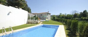 A swimming pool with a stone house in the background.