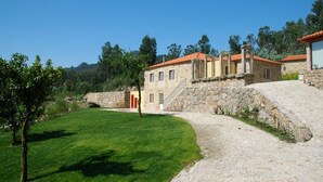 A stone building with a red-tiled roof, a stone staircase, and a grassy area. - Villa Anisa - Four Bedroom Villa, Sleeps 8 (Estorãos)