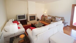 A living room with a fireplace, two sofas, a coffee table, and a television. - Villa Alexa - Six Bedroom Villa, Sleeps 12 (Fornelos)