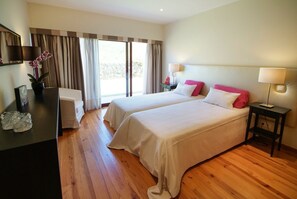 Una habitación de hotel con dos camas, un escritorio y una silla.