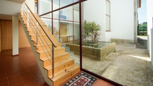 A modern interior with a wooden staircase leading to a glass door opening to a courtyard. - Villa Alexa - Six Bedroom Villa, Sleeps 12 (Fornelos)