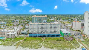 A multi-story hotel with a central courtyard, parking garage, and a view of the surrounding neighborhood.