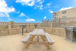 Relax in a semi- patio area with a rustic picnic table and trash receptacle.