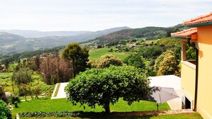 A view of a hillside property with a well-maintained garden, a large tree, and a building with a red roof. - Villa Ava - Four Bedroom Villa, Sleeps 8 (Refóios do Lima)