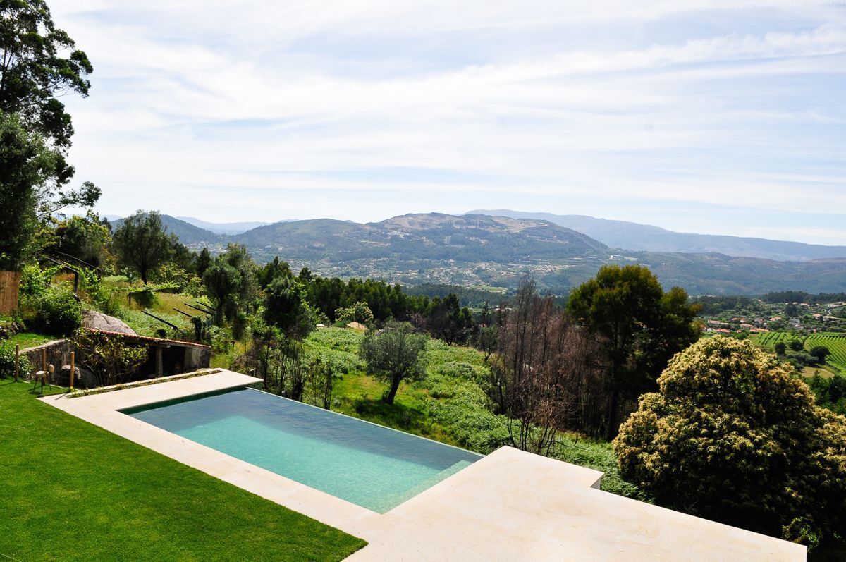 A swimming pool with a view of rolling hills and distant mountains.