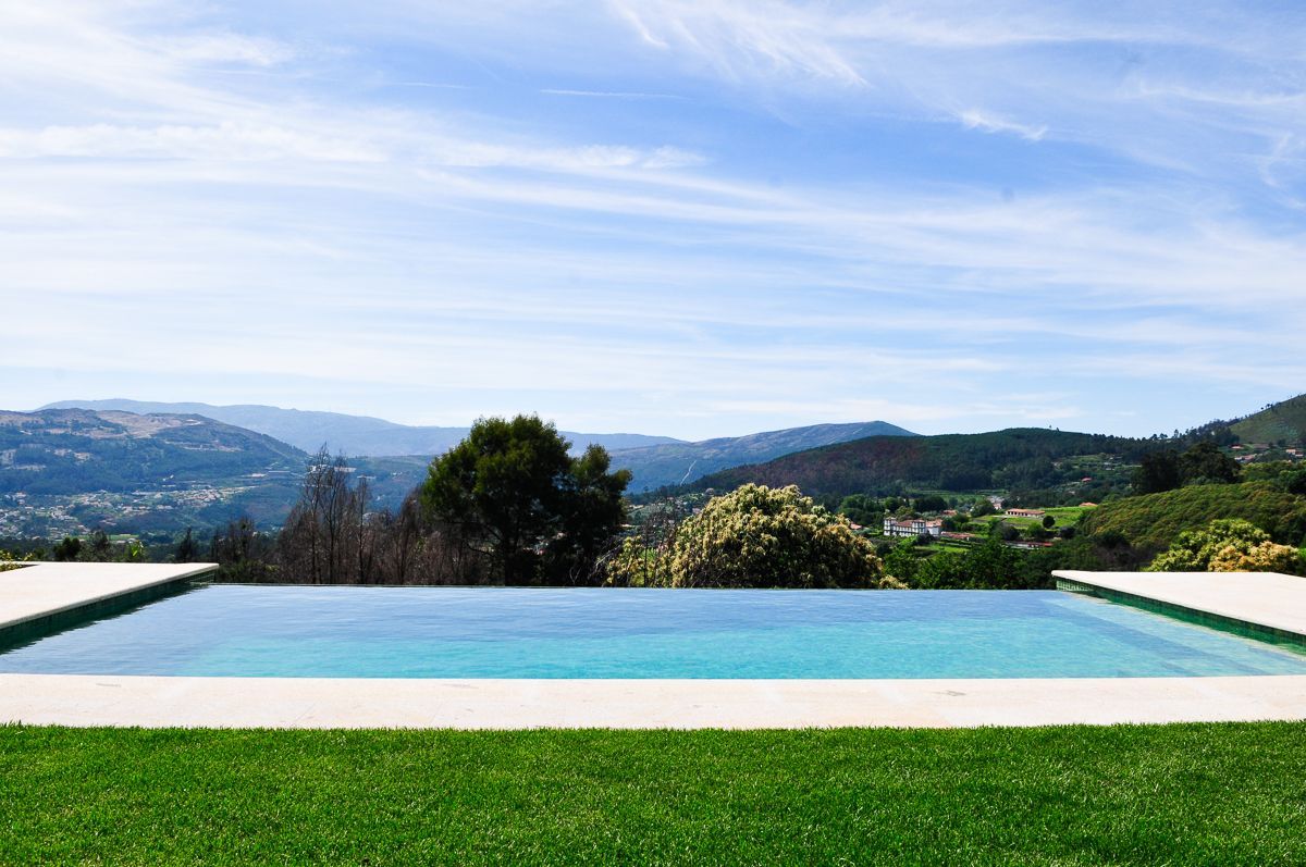 Ein rechteckiger Pool mit freiem Blick auf ferne Hügel und eine Stadt.